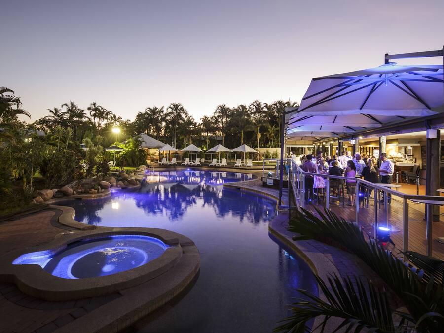Een buitenzwembad, parasols bij het zwembad en ligstoelen
