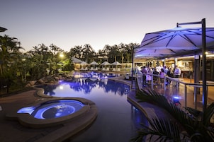 Una piscina al aire libre, sombrillas, sillones reclinables de piscina