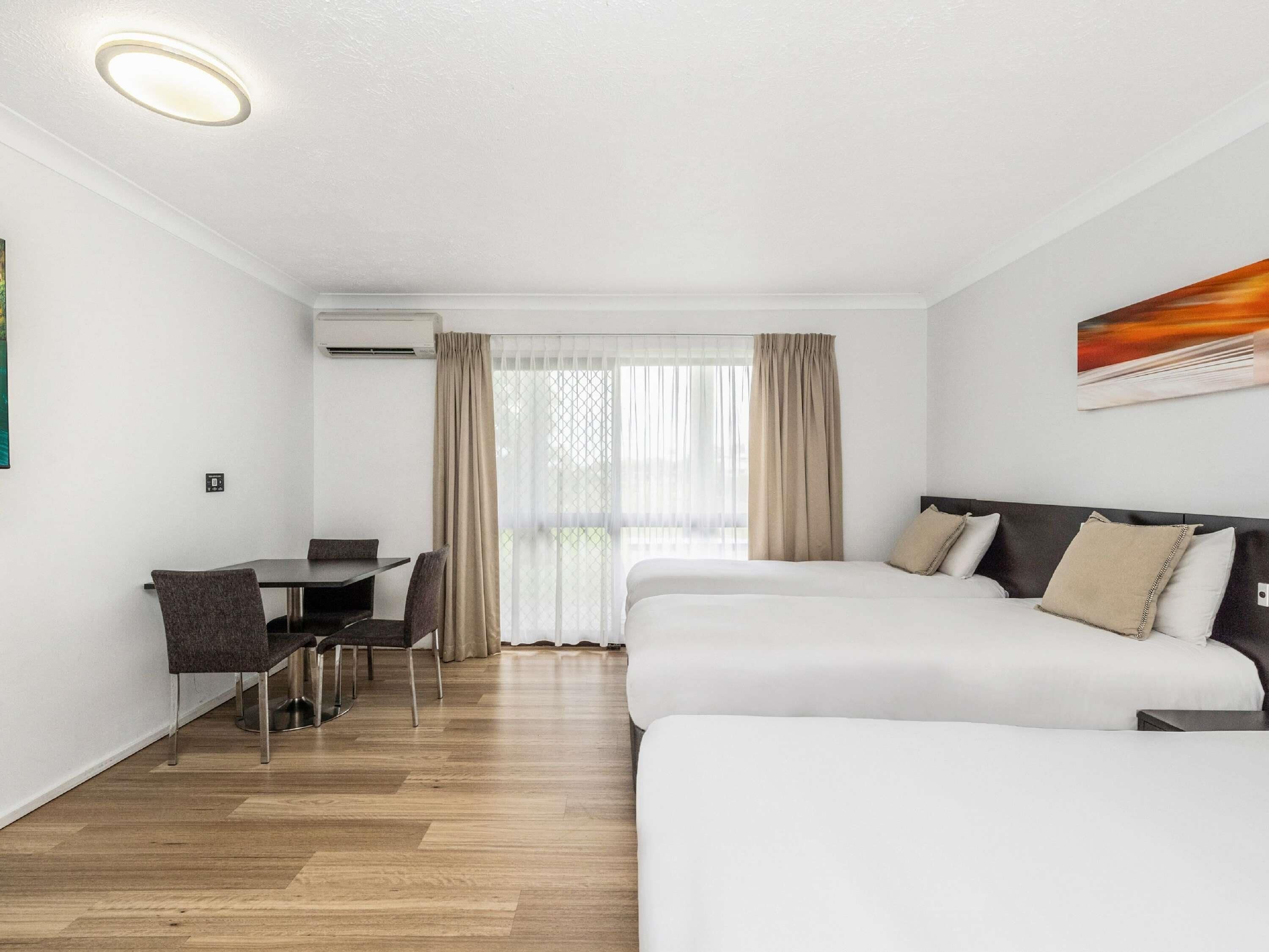 A hotel room with a bed, a desk, and a chair.