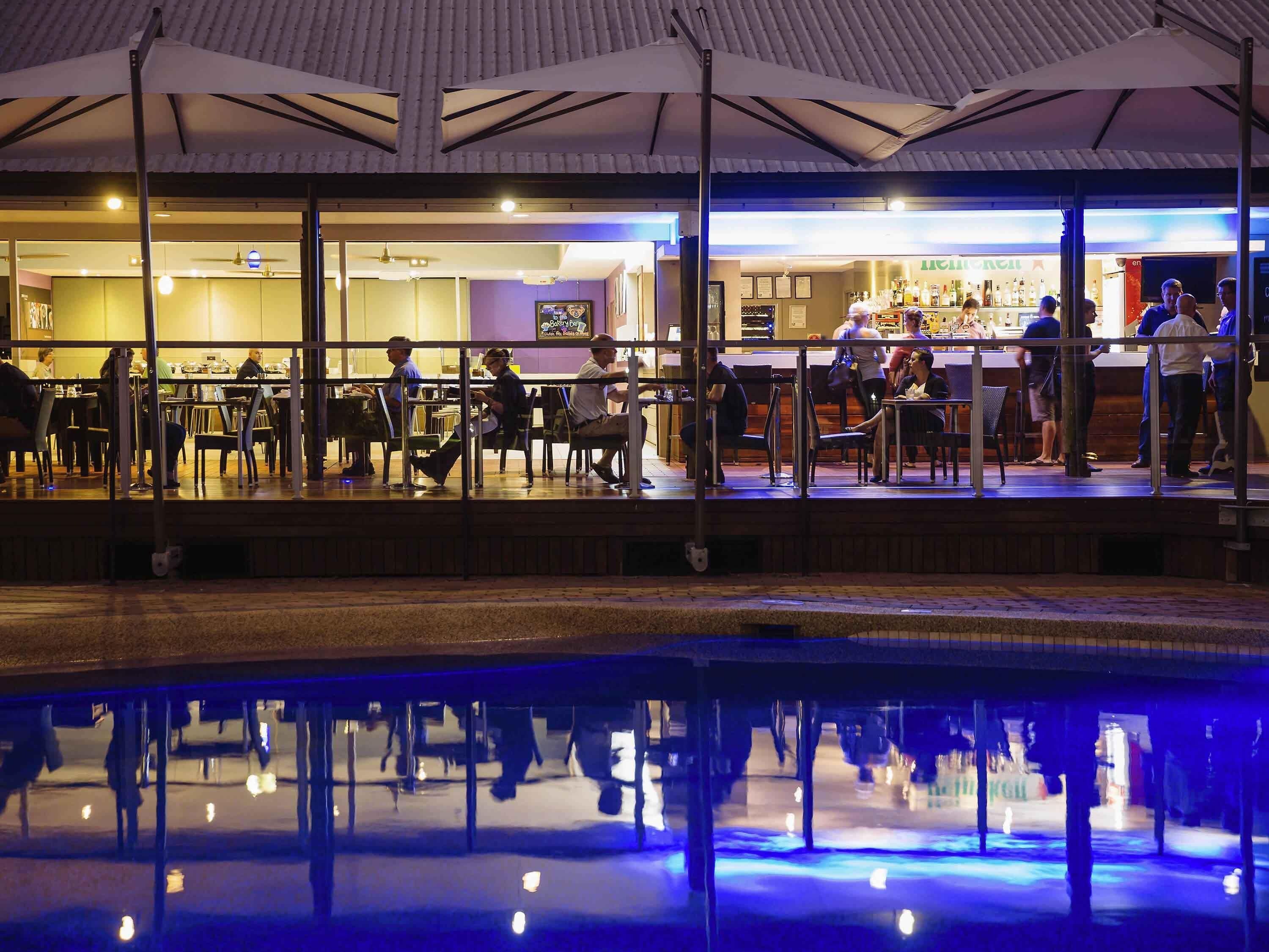 An indoor bar with a pool reflecting the interior.