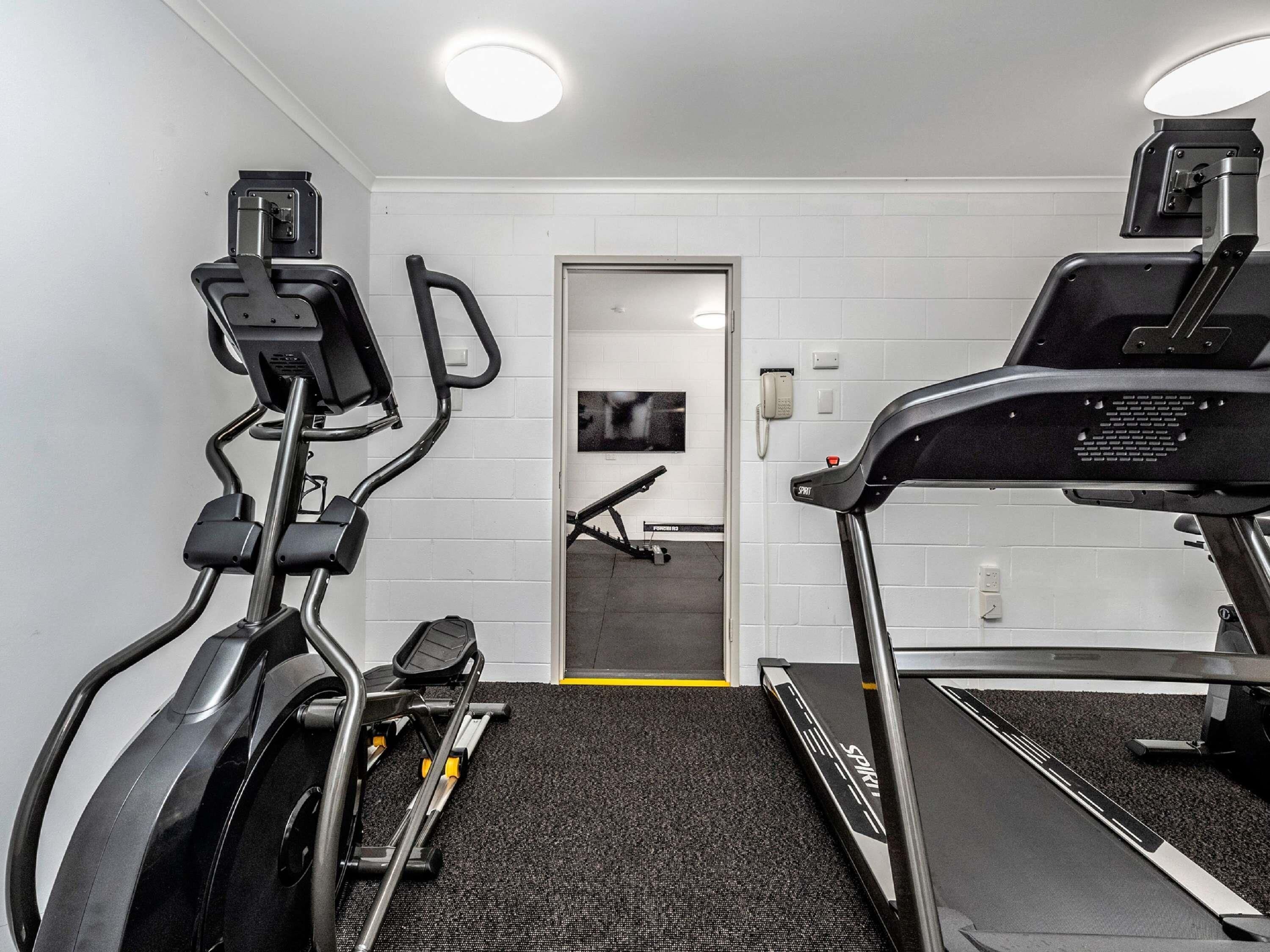 A gym with treadmills, an elliptical, and a stationary bike.