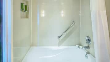 Uma casa de banho moderna com banheira, chuveiro e barra de apoio.