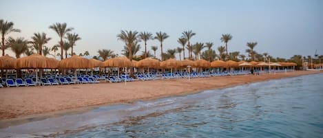 PĂ„ stranden, solstolar, parasoller och strandhanddukar