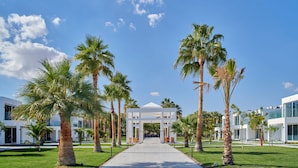 A pathway leading to a white gazebo surrounded by palm trees and modern buildings. - Maritim Jolie Ville Resort & Casino Sharm El Sheikh (Sharm El Sheikh)