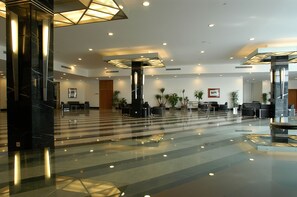 Tilava aula, jossa on kiillotettu marmorilattia, modernit valaisimet ja useita oleskelualueita.