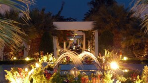 A well-lit garden with a central fountain, surrounded by lush greenery and palm trees. - Maritim Jolie Ville Resort & Casino Sharm El Sheikh (Sharm El Sheikh)