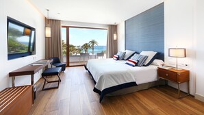 A modern hotel room with a large bed, a desk, and a view of the ocean. - Hotel Son Caliu Spa Oasis (Calvia)