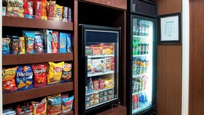 Un espace dédié aux en-cas, avec des étagères remplies de chips et un réfrigérateur contenant des boissons.