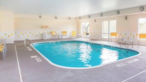 Une piscine intérieure à l’eau claire, avec des murs et un sol carrelés.