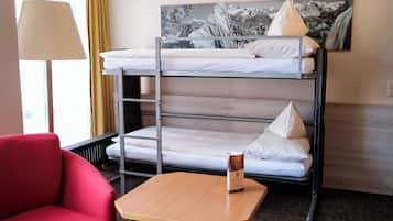 A bunk bed with a view of a mountain landscape, a red chair, and a table with a brochure.
