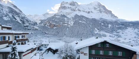 A snow-covered mountain village with a hotel named "Hotel Tschuggen."