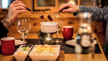 A dining table with a white ceramic dish, a red cup, and a glass of white wine.