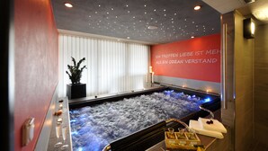 A spa area with a hot tub, candles, and a wall with a motivational quote.