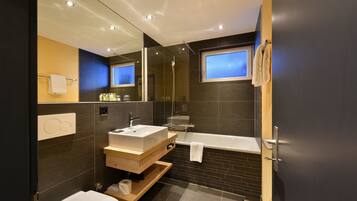 Une salle de bain moderne avec une baignoire, un lavabo et un miroir.