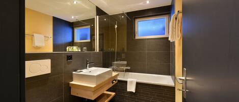 Une salle de bain moderne avec une baignoire, un lavabo et un miroir.