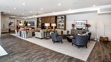 A spacious living room with a fireplace, modern furniture, and a large bookshelf.