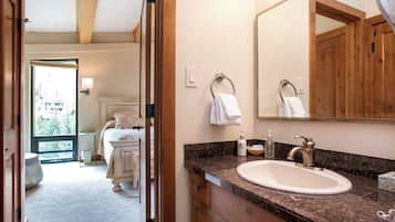A bathroom with a large mirror, a sink, and a towel rack.