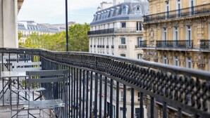 A balcony with metal railings and a table with chairs. - Hotel Park Lane Paris (Paris)