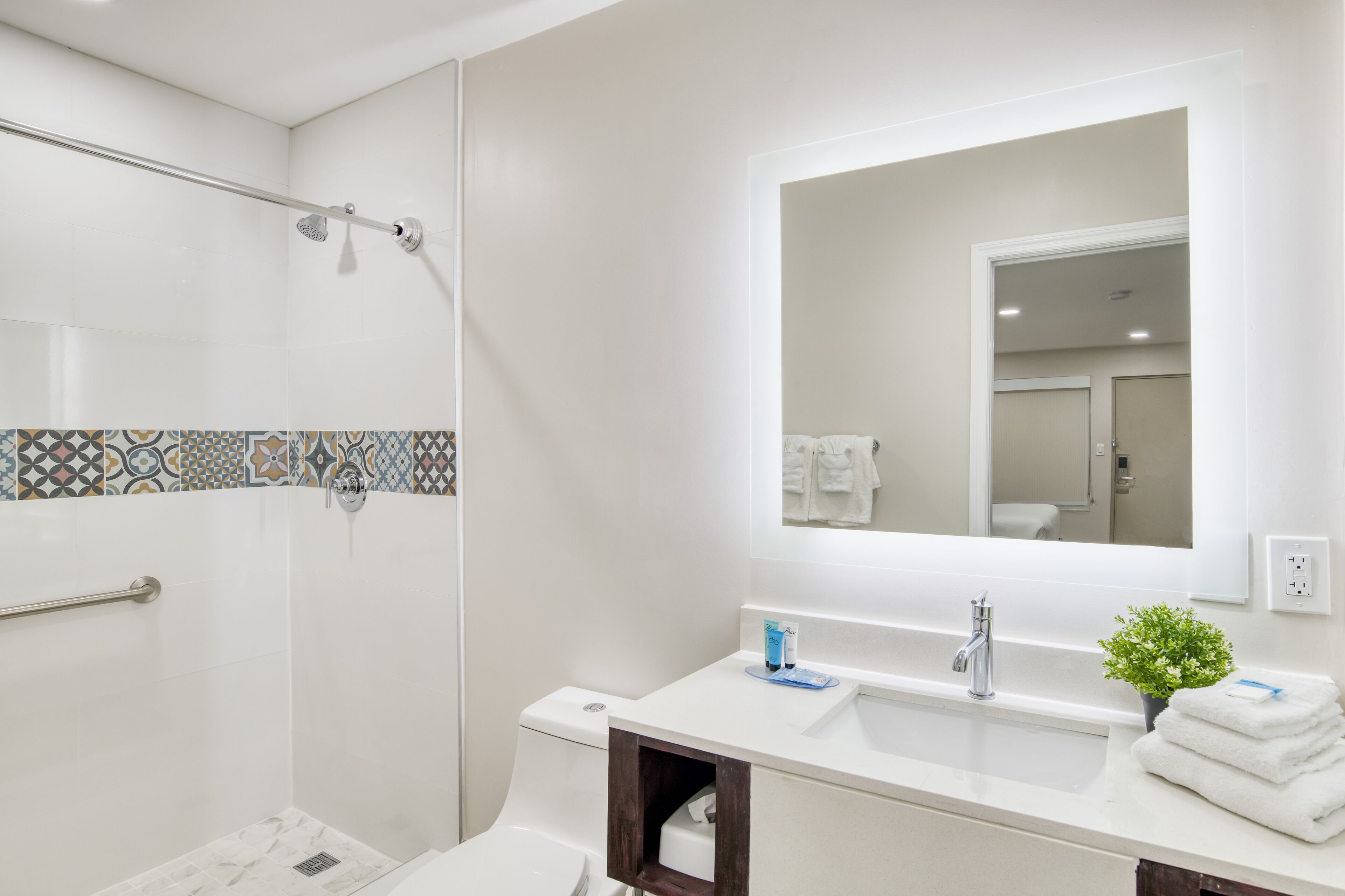A modern bathroom with a shower, toilet, and sink.