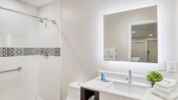 Un baño moderno con ducha, inodoro y lavamanos.
