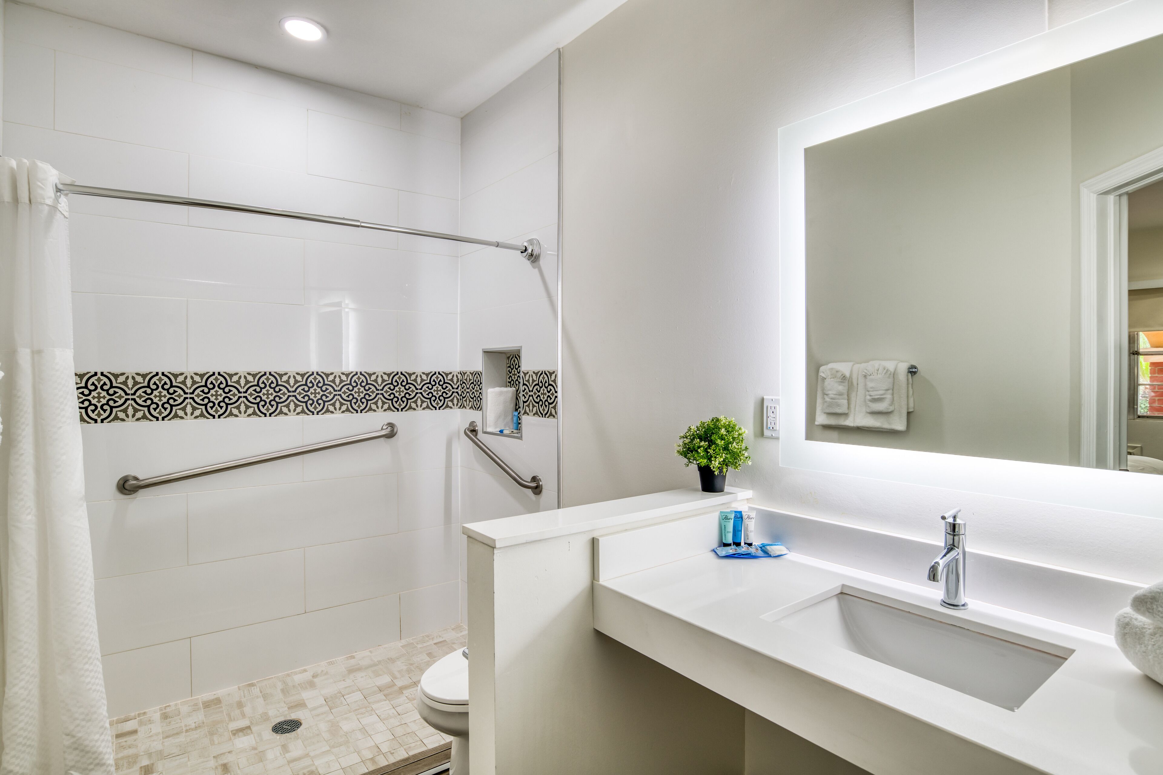 A modern bathroom with a shower, toilet, and sink.