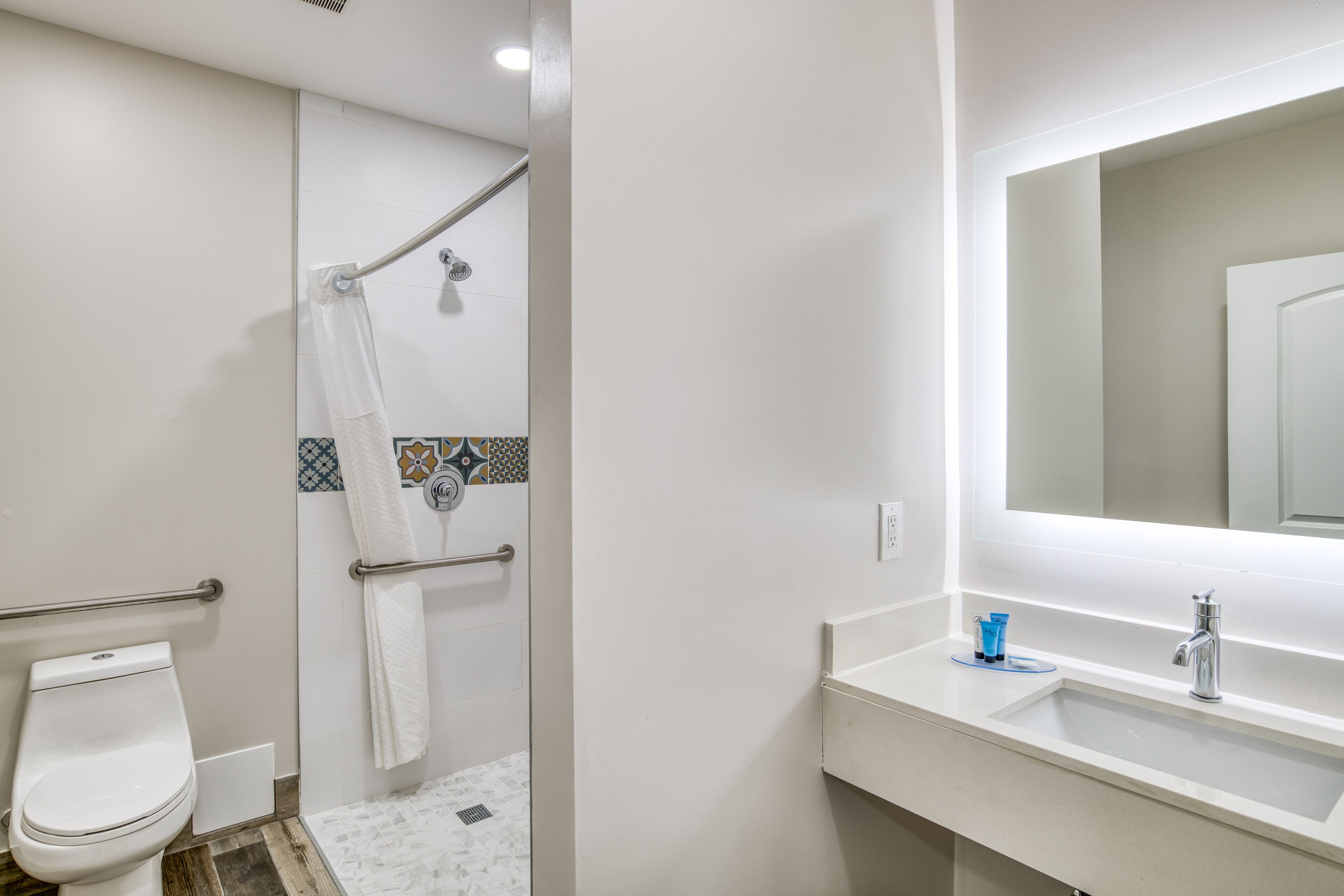 A bathroom with a toilet, shower, and sink.