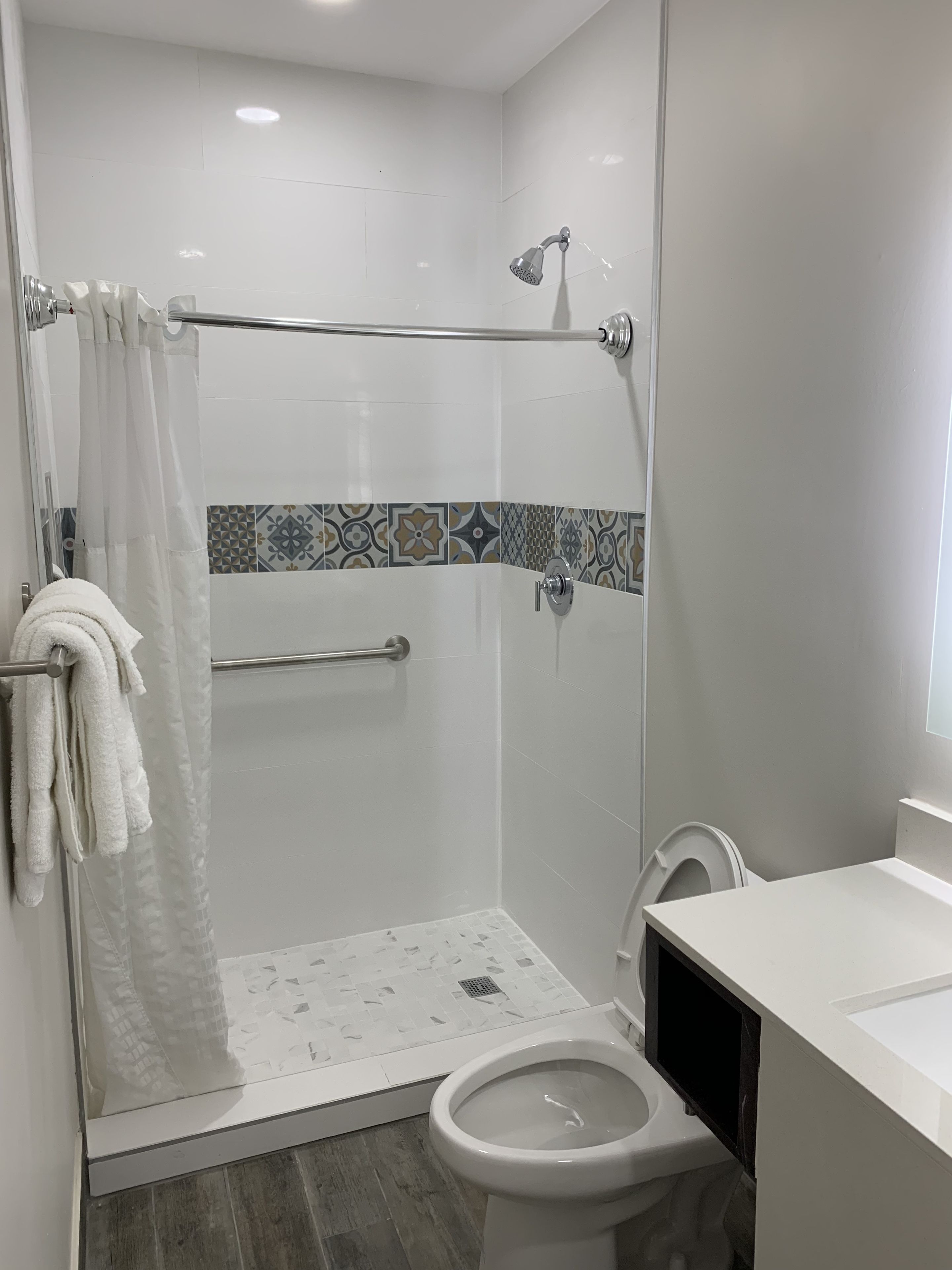 Een moderne badkamer met een douche, toilet en wastafel.