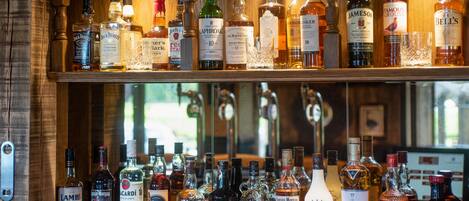 A bar with multiple shelves of various liquor bottles.