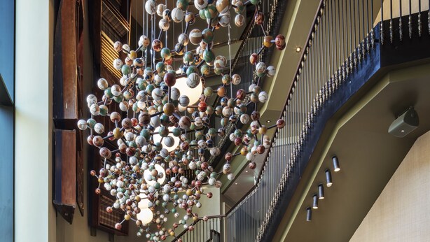 A spacious lobby with a grand staircase, a decorative ceiling, and a reception desk with a 'Graduate' sign.
