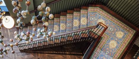 A spiral staircase with ornate railings and patterned carpet.