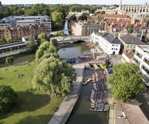 An aerial view of a riverside area with a bridge, boats, and buildings. - Graduate by Hilton Cambridge (Cambridge)