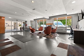 Ein modernes Interieur mit einer Rezeption, einer Sitzgelegenheit und großen Fenstern.