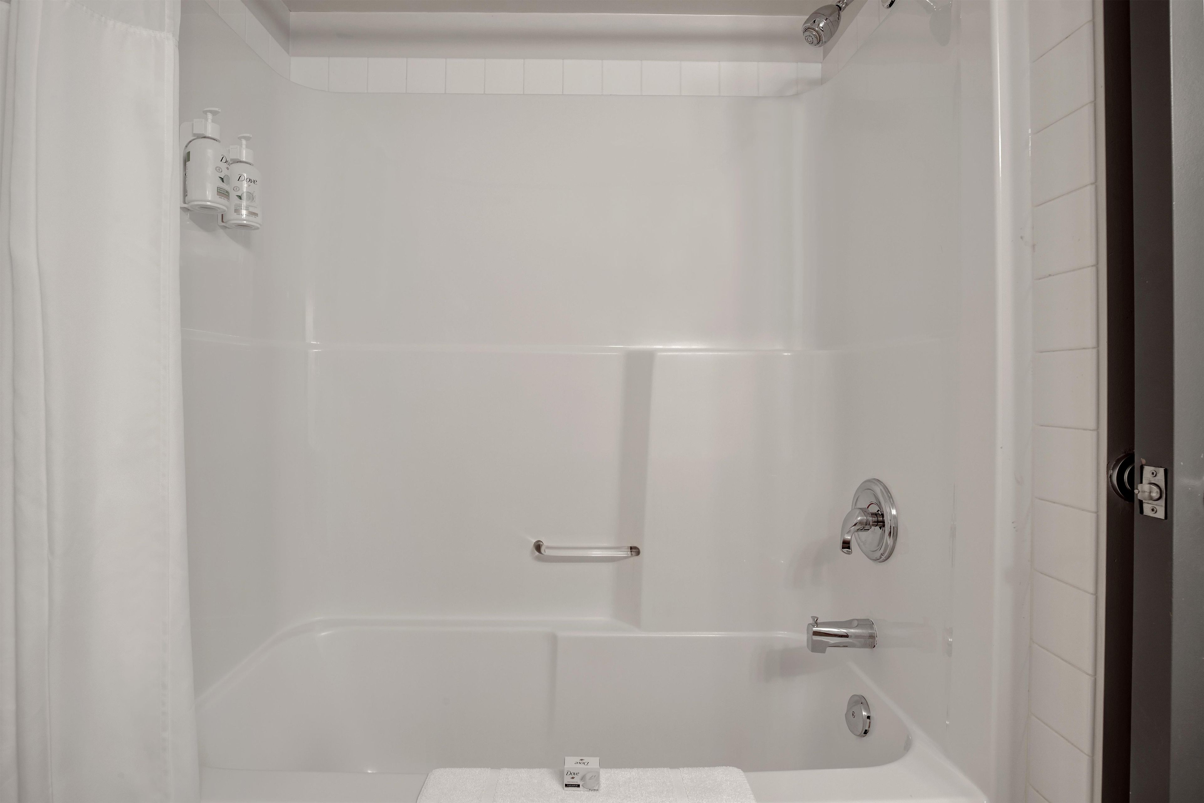 A white bathroom with a bathtub, a shower, and a toilet.