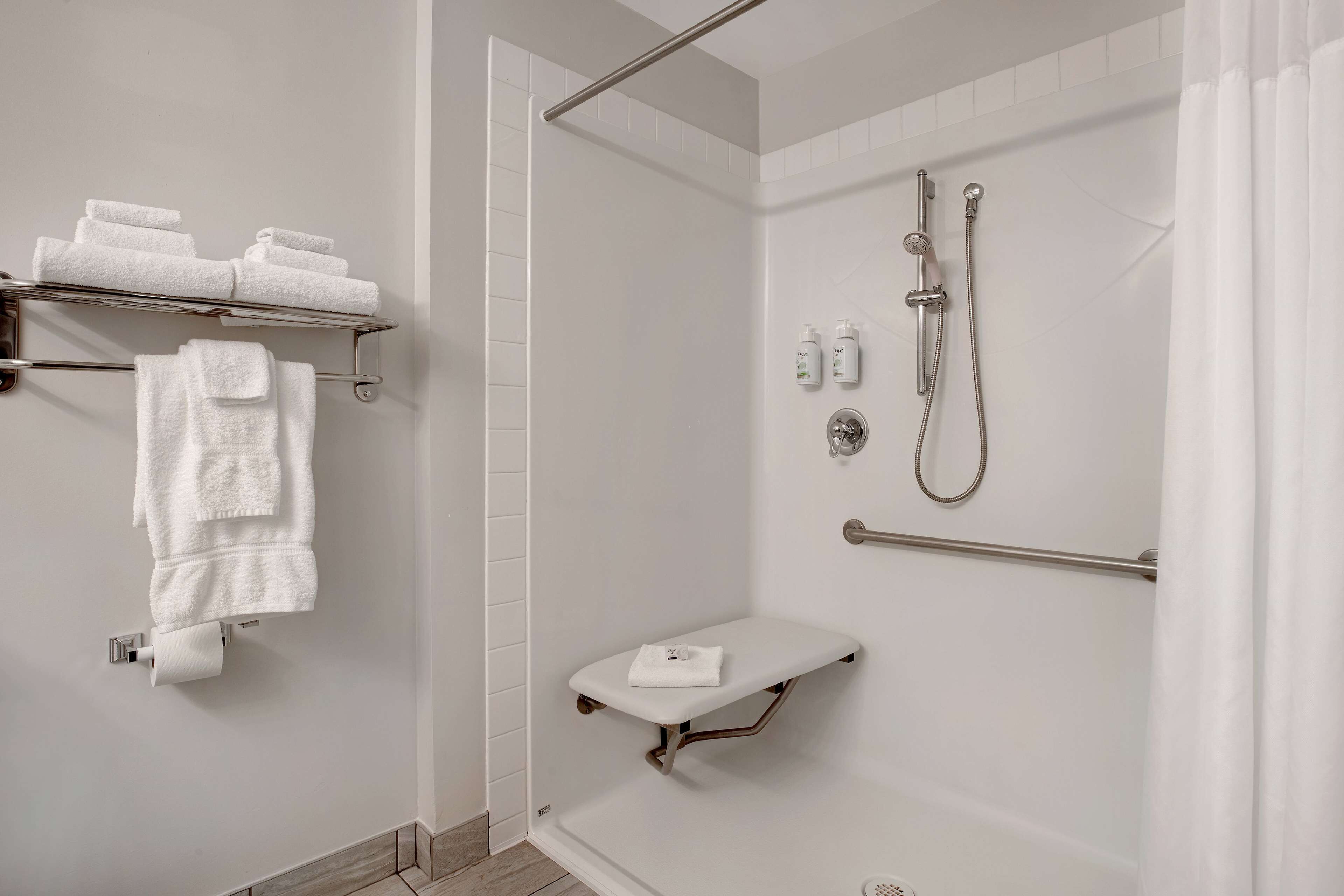 Ein modernes Badezimmer mit Dusche, Handtuchhalter und Toilettenpapierhalter.