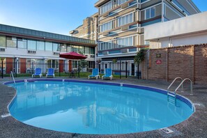 Piscine extérieure en saison, parasols, chaises longues