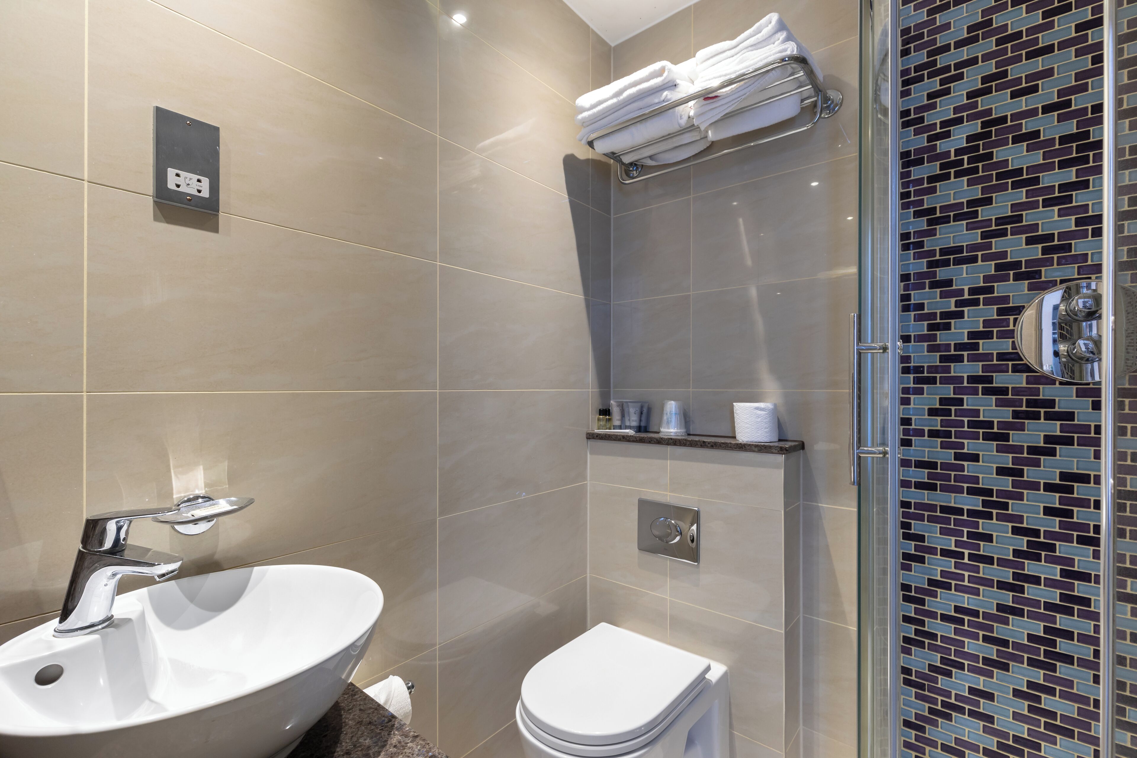 A modern bathroom with a sink, toilet, and shower area.