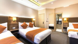 A hotel room with two beds, a bathroom, and a small seating area. - Sidney Hotel London Victoria  (London)