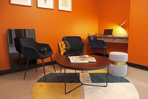 Cozy retreat with a compact desk, comfortable sofa, and warm decor.