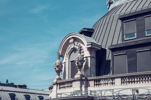 Stunning architectural details adorn this historic building, featuring an ornate arched window and decorative balustrade.