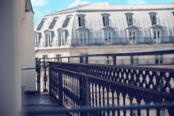 Enjoy the classic views from this balcony with an ornate wrought iron railing.