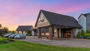 A hotel with a covered entrance, a parking lot, and a clear sky. - Best Western Plus New Ulm (New Ulm)