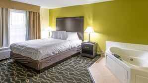 A hotel room with a bed, bedside lamps, a nightstand, and a bathtub.