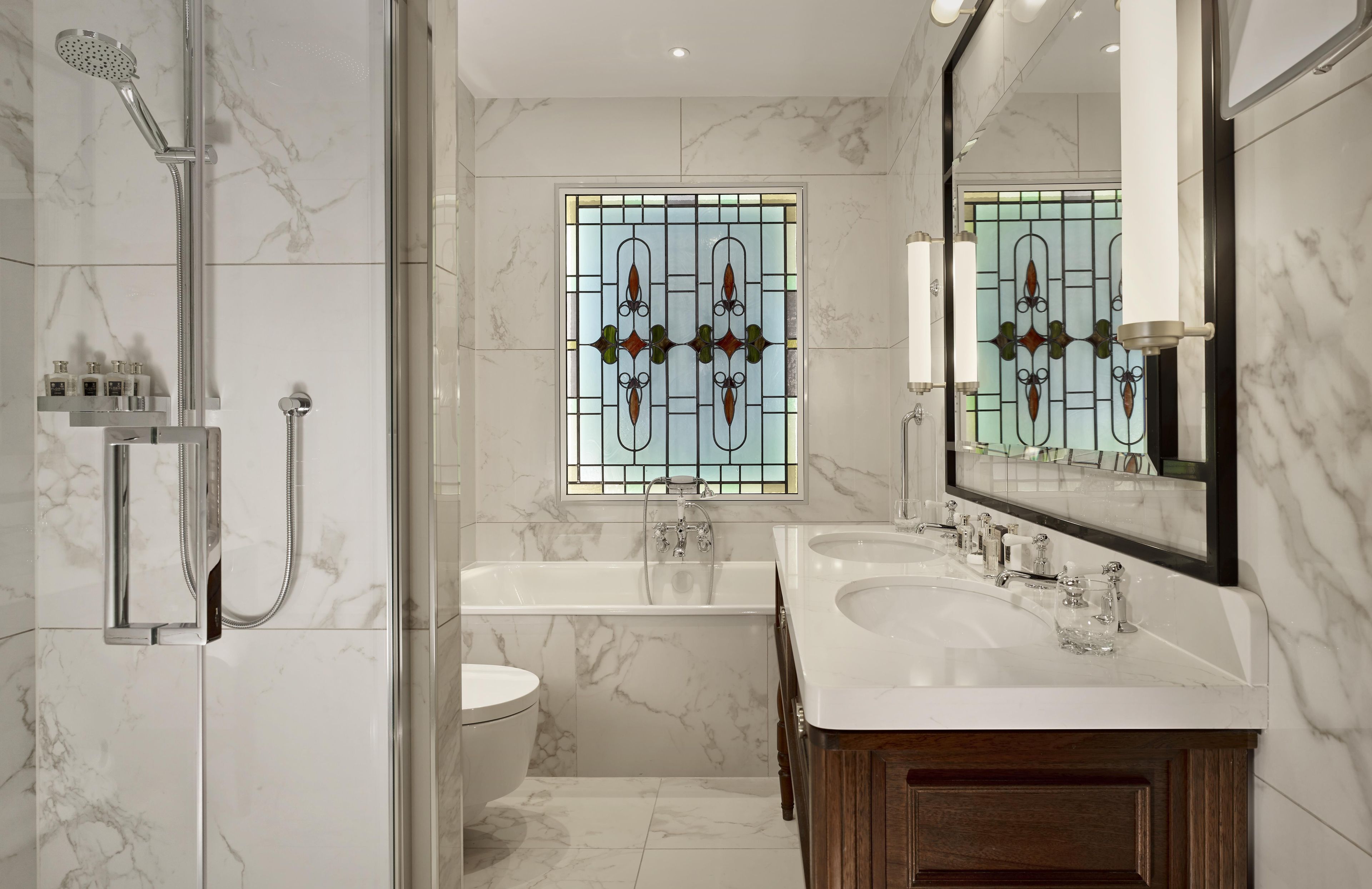 Un bagno moderno con doccia vetrata, vasca freestanding e mobile bagno con doppio lavabo.