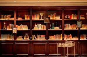 A library with bookshelves, a trophy, and a framed picture.