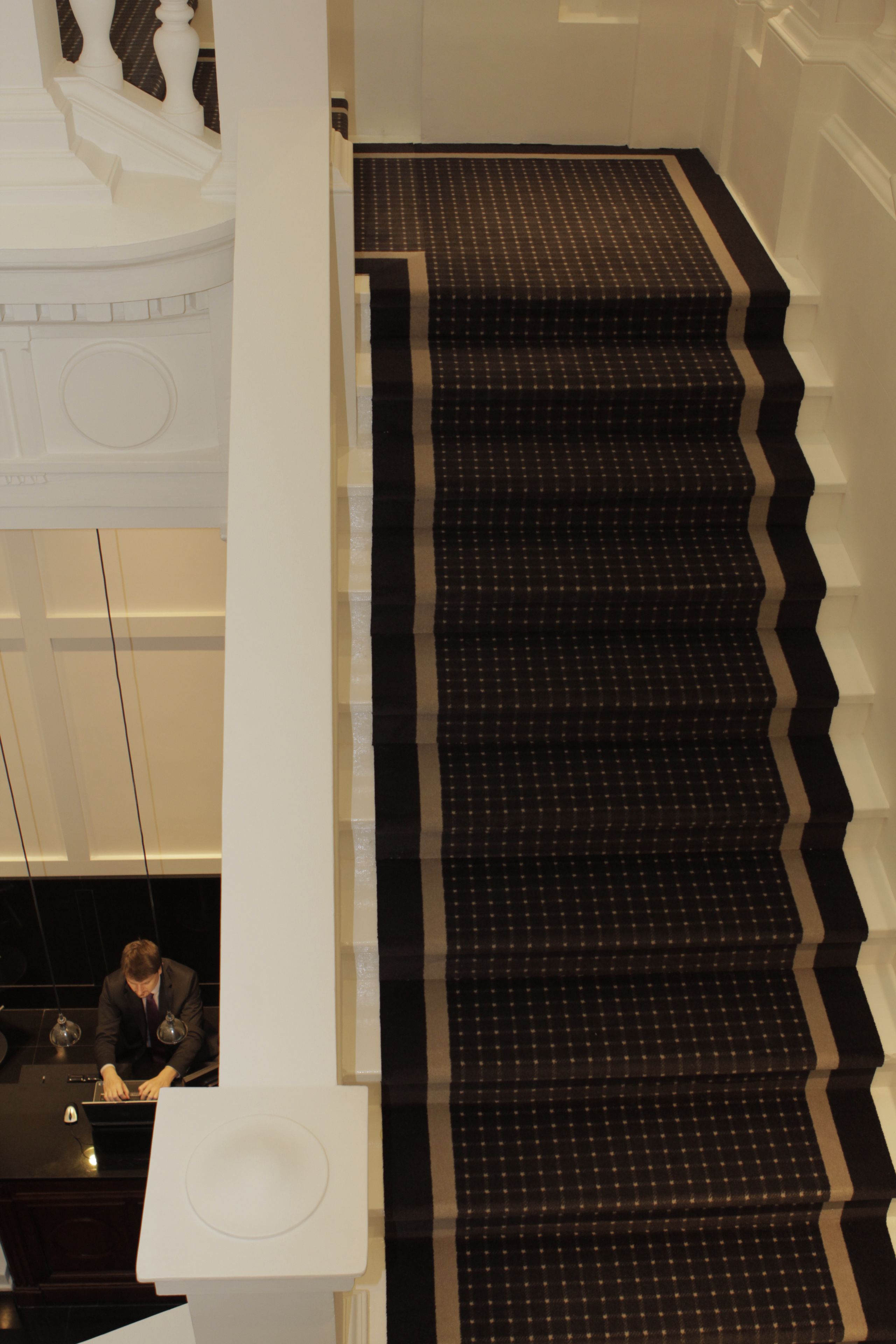 A staircase with a black and white striped pattern, leading to a higher floor.