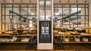 Montaje tipo bufé con diferentes alimentos y una máquina de café.