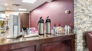 A coffee station with two hot water dispensers, a coffee maker, and two coffee dispensers on a counter. - Red Roof Inn PLUS+ & Suites Houston - IAH Airport SW (Houston)