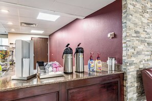 A coffee station with two hot water dispensers, a coffee maker, and two coffee dispensers on a counter. - Red Roof Inn PLUS+ & Suites Houston - IAH Airport SW (Houston)