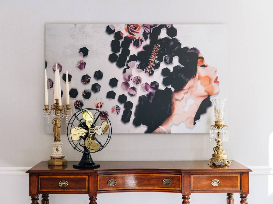 A wooden desk with a globe, a candelabra, and a painting of a woman.