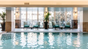 An indoor swimming pool with four chairs and potted plants. - The Read House Hotel (Chattanooga)